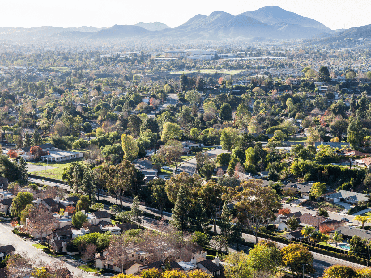 Aerial view of Thousand Oaks, California with tree-lined neighborhoods and mountain landscapes in the distance.