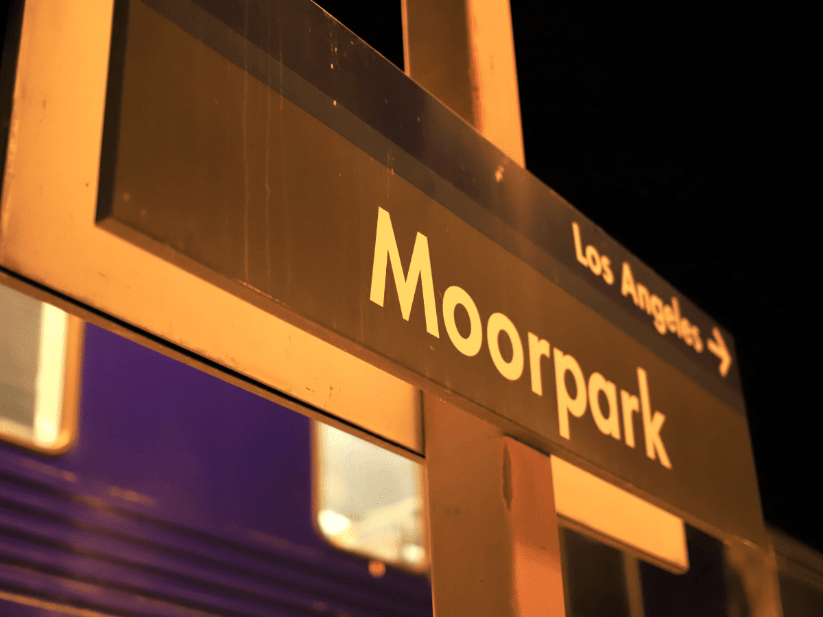 Night view of the Moorpark station sign with passing train lights in Moorpark, California.